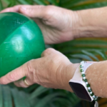 Persona mayor realizando ejercicio físico con una pelota para un envejecimiento activo y saludable.